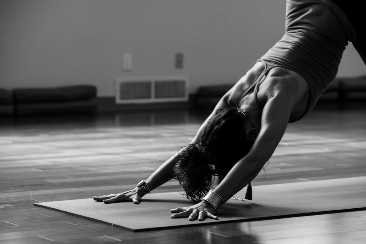 Person performing a bird-dog exercise on a yoga mat for lower back pain relief