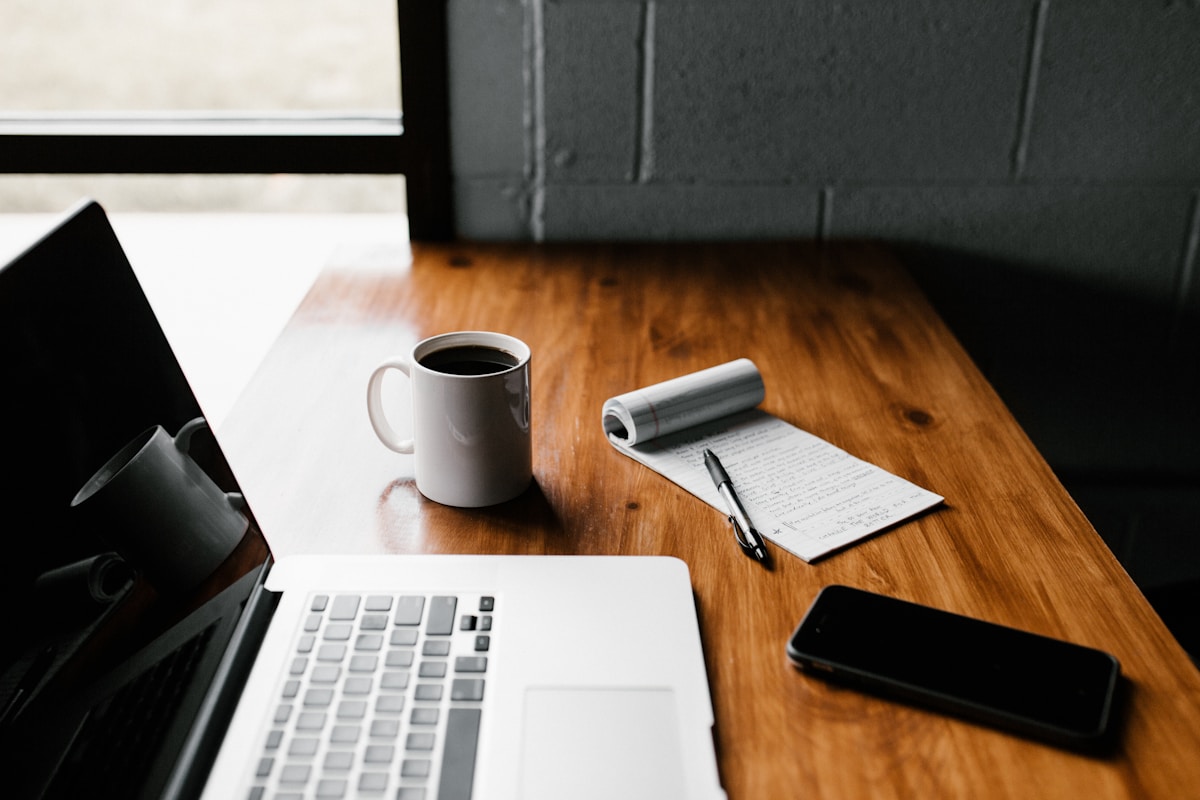 Person working at a desk with a laptop in morning light, focused and productive