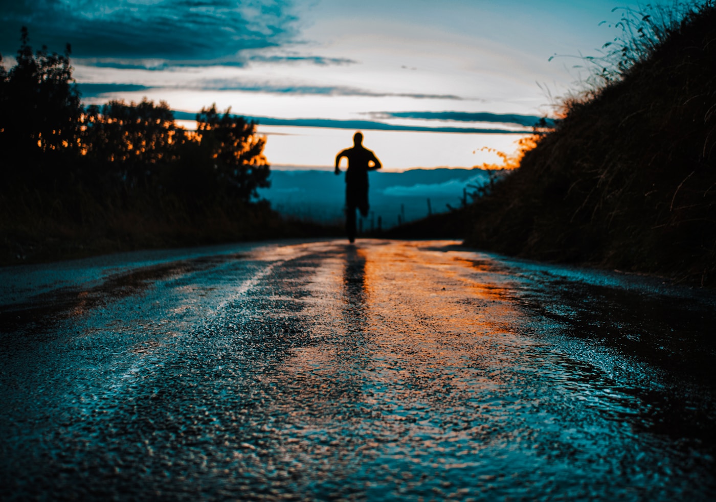 Silhouette of a runner on an open trail at sunrise, symbolizing exercise as a path to longevity and healthier aging