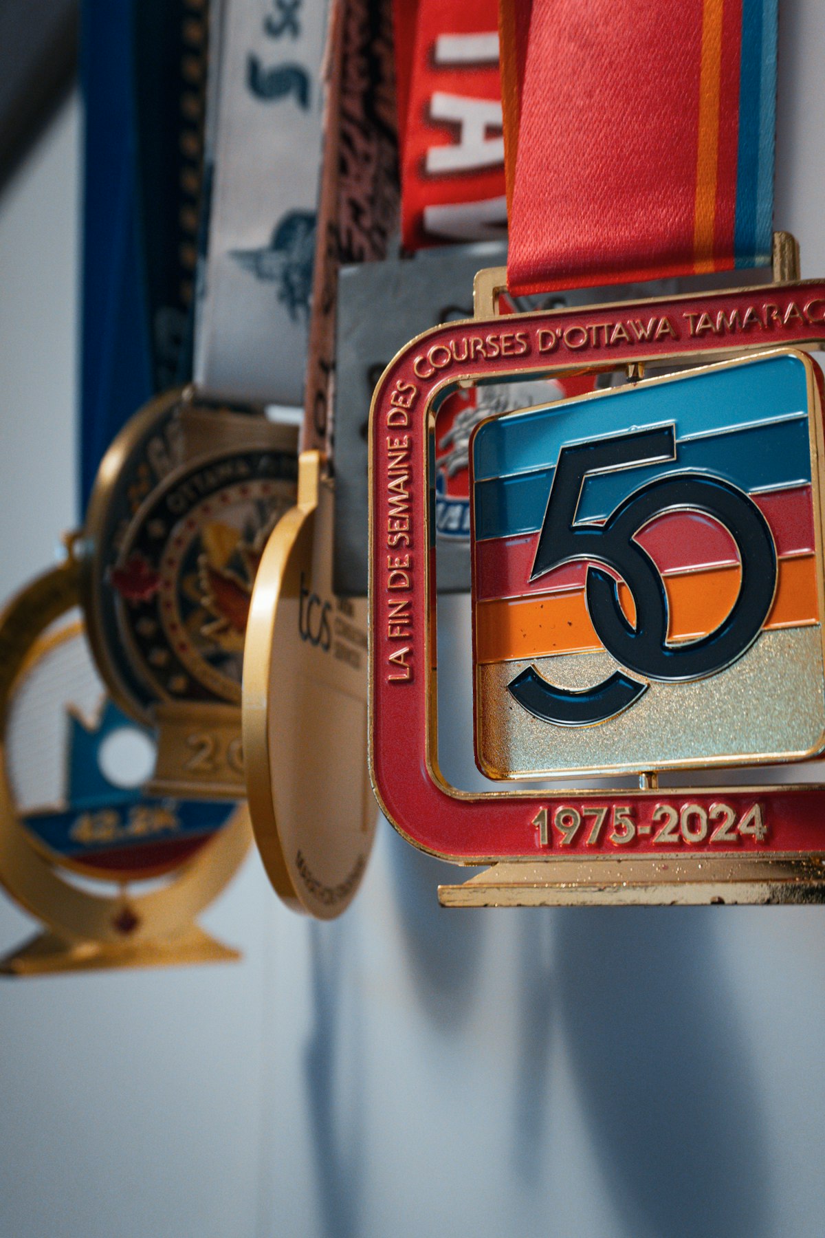 Collection of athletic race medals hanging on a wall