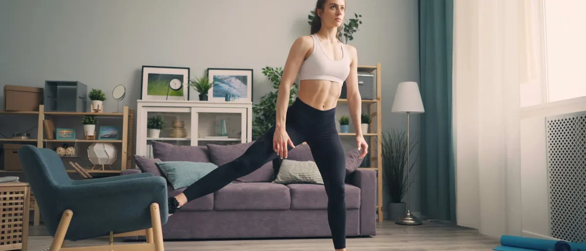 Nainen, joka suorittaa kevyen kyykkymuunnelman HIIT-kotitreenin aikana