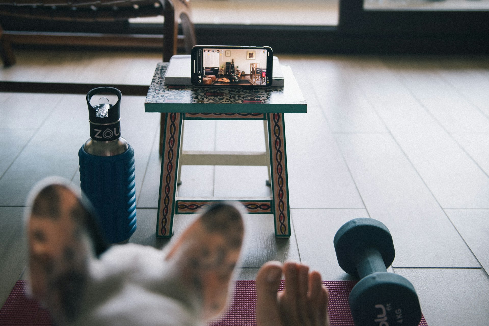 Person opening a home workout app before a short living-room session
