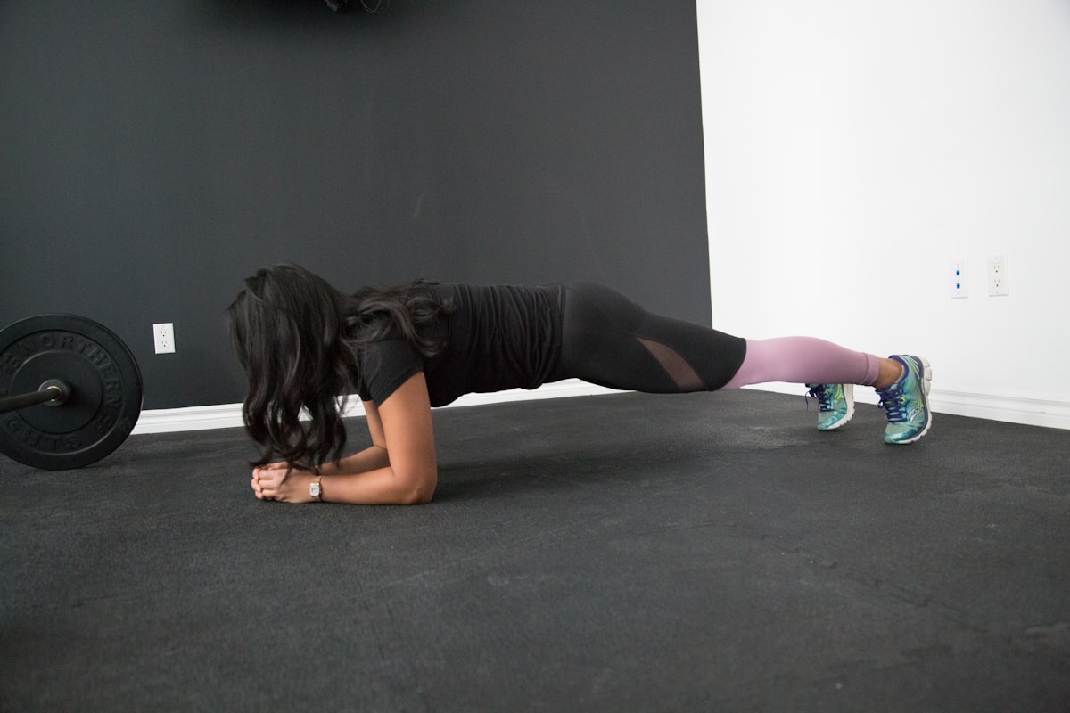 Person holding a wall sit position against a white wall in a home setting