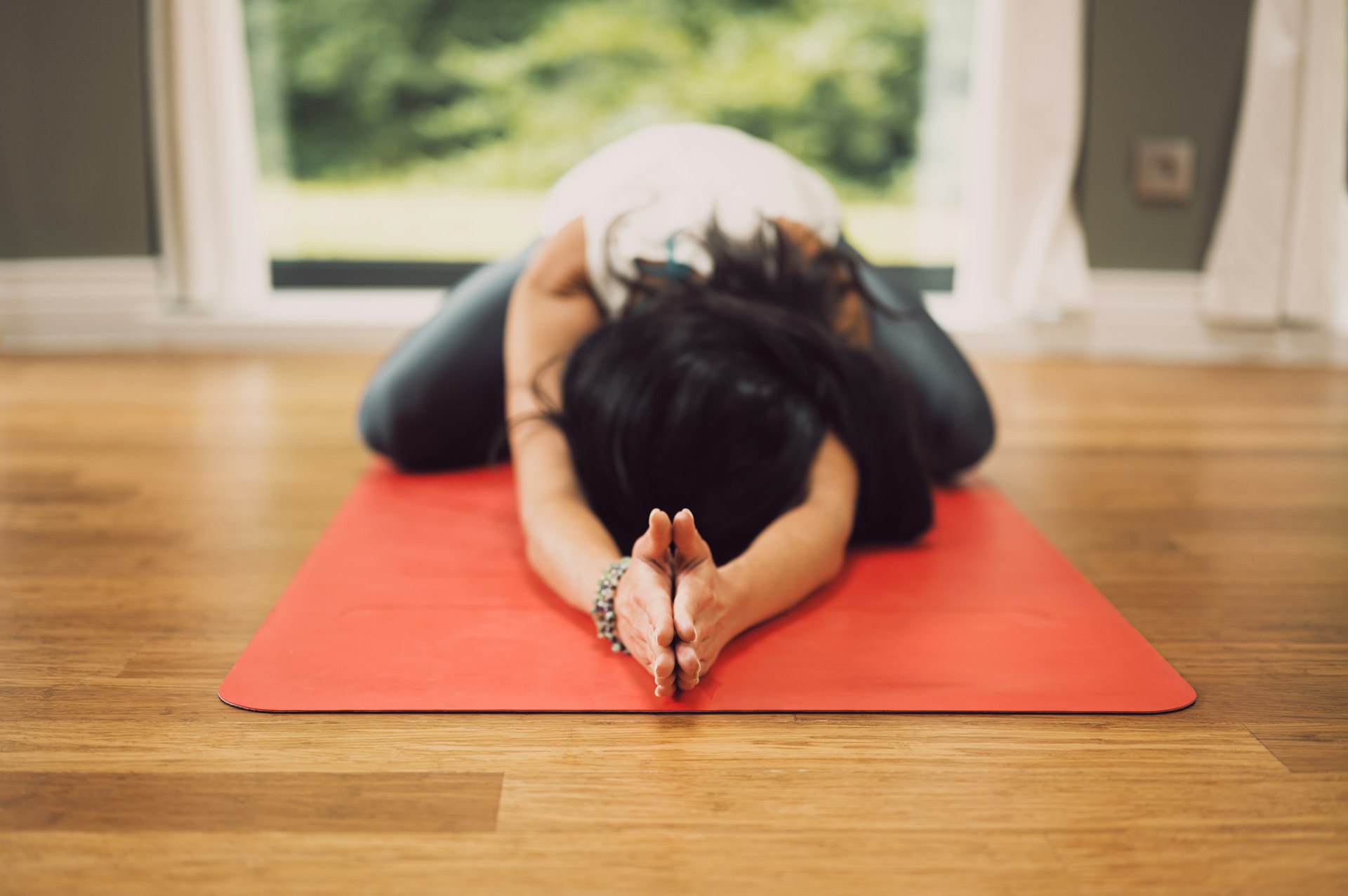 Woman resting on a yoga mat during a calm pelvic-floor awareness session at home